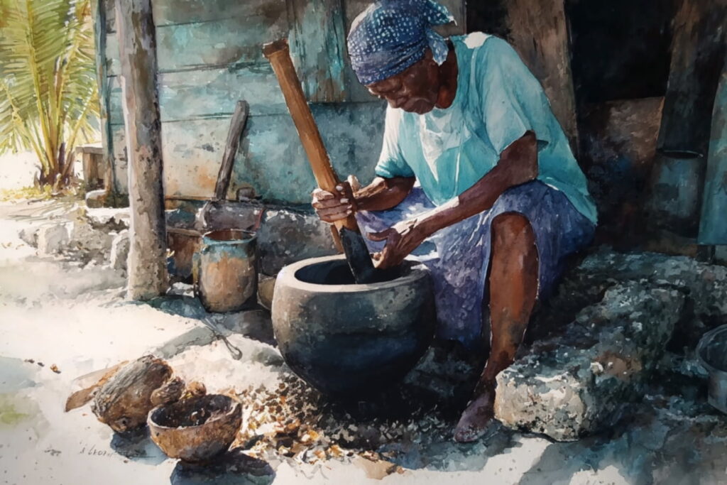 Roasted castor beans being crushed into a paste using a traditional mortar and pestle